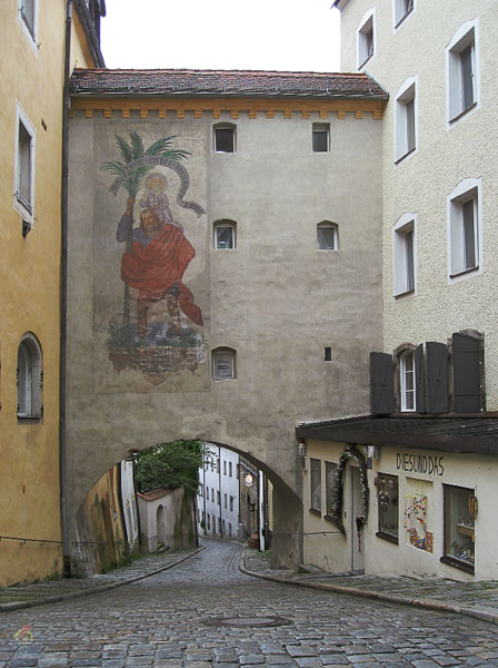 cobbled street with a painted building above