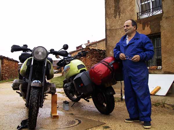 Two motorcycles, wet clay, and a Spaniard in blue coverall