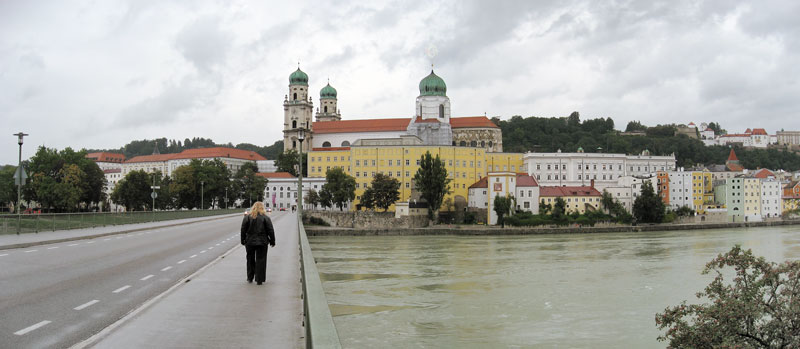 River, bridge, and towers and yellow and white houses on the other side of the bridge